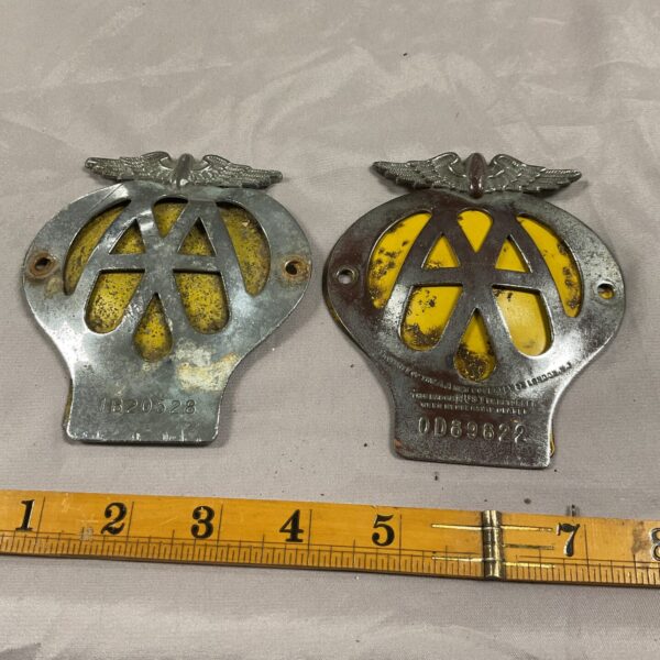 Pair of vintage A A grill badges for classic cars.
