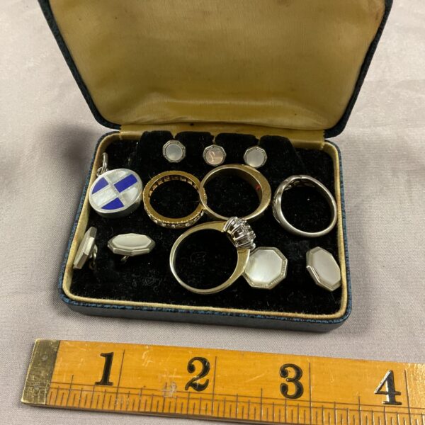 Vintage mother of pearl cufflinks and collar studs set displayed on velvet.