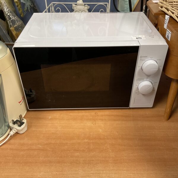 White Tesco microwave appliance on a wooden surface.