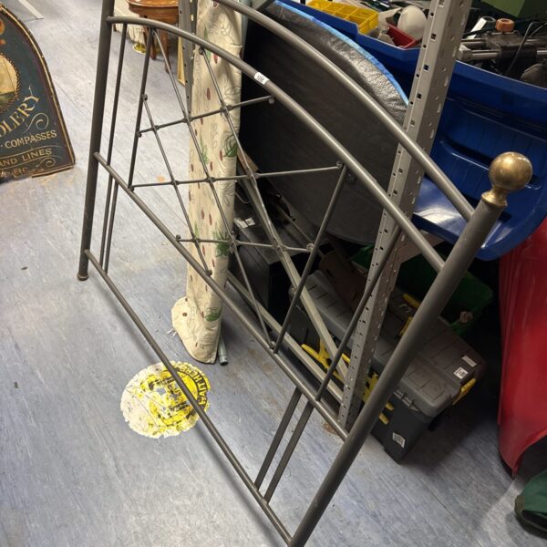 Vintage metal bed headboard with decorative design.