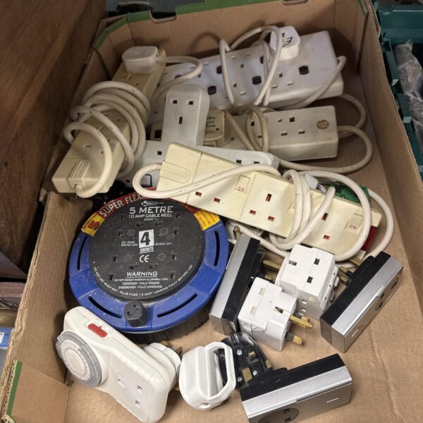 Assorted plug adapters and extension lead collection for electrical connections.