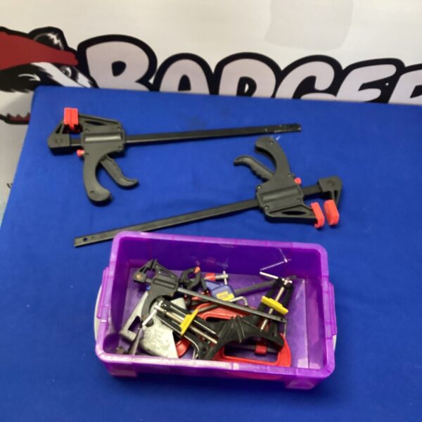Assorted metal clamps in a workshop tool lot.