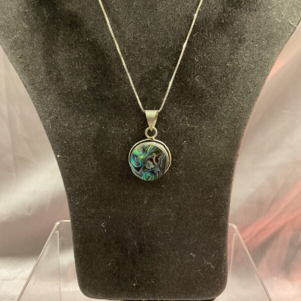 Iridescent abalone shell pendant on a silver necklace.