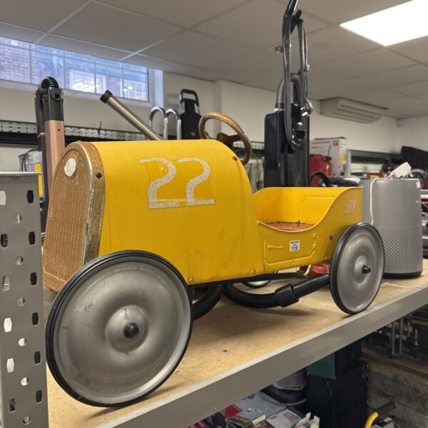 Yellow vintage Baghera Speedster pedal car with racing number.