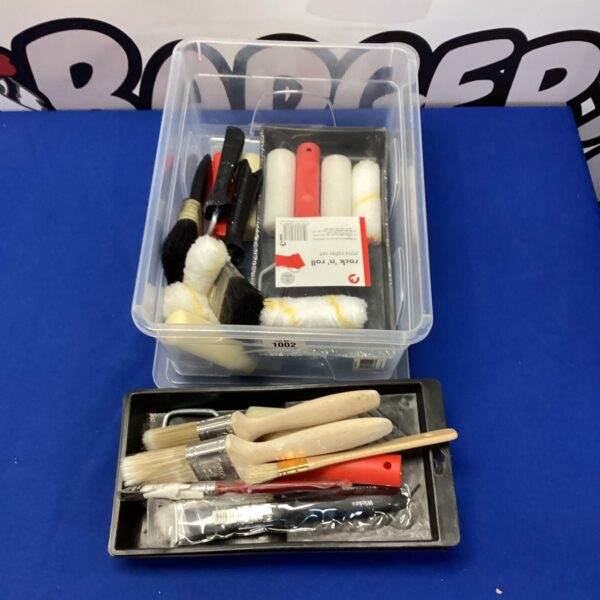 Assorted paint brushes and rollers in a plastic tub.