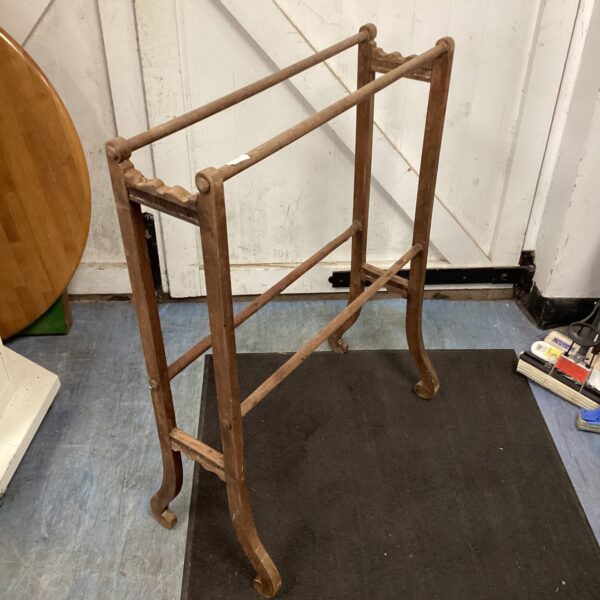 Side view of a vintage wooden clothes horse drying rack.