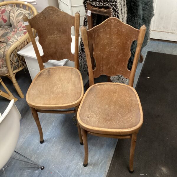 Pair of vintage wooden bistro chairs with worn patina.