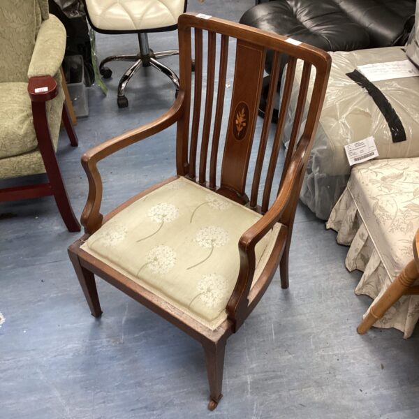 Antique bedroom chair with casters and floral upholstery.