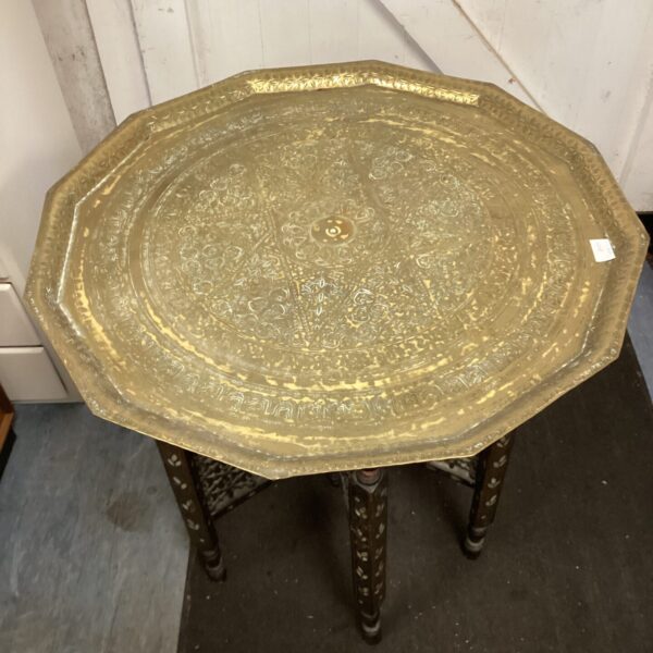 Intricate Arabic brass folding table with ornate embossed patterns.