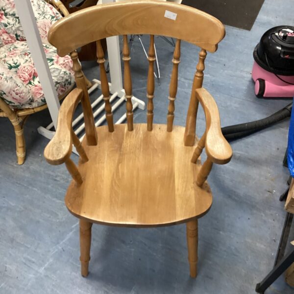 Vintage pine armchair with curved back and wooden armrests.