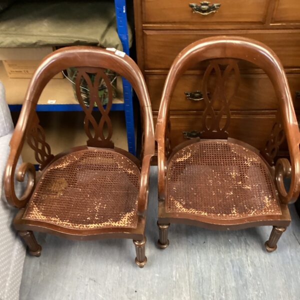 Pair of vintage rattan seated chairs with wooden frames.
