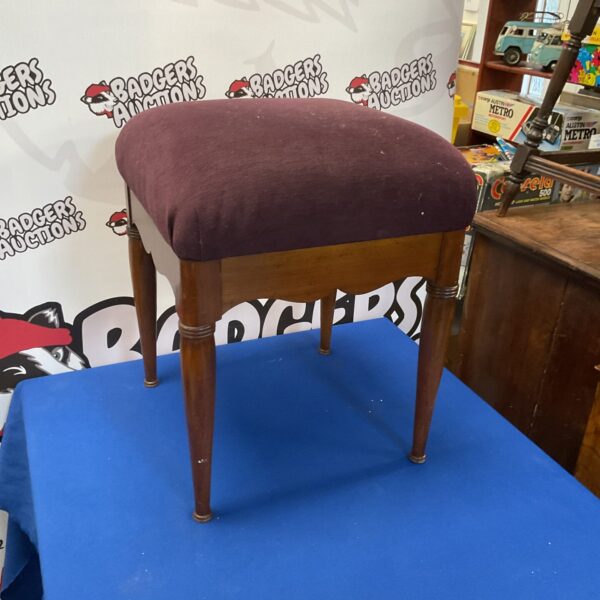 Vintage piano stool with patterned padded seat and wooden legs.