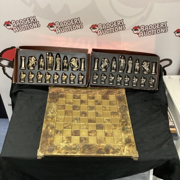 Ornate chess set with detailed Greek figurine pieces on a wooden board.