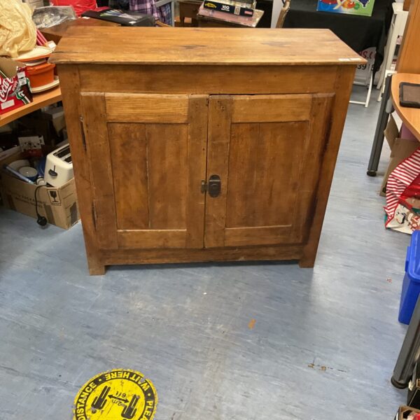 Front view of a vintage oak cupboard with panelled doors.
