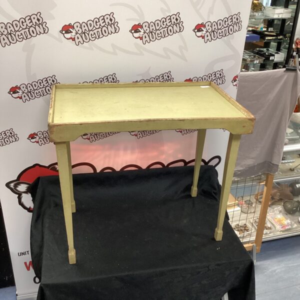 Front view of a vintage wooden tray table with a black cloth underneath.