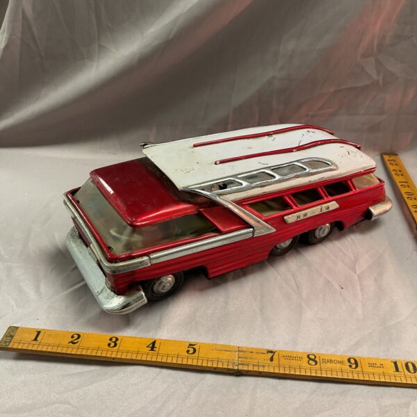 Red vintage tin toy car with battery operation.
