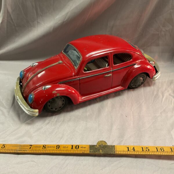 Red vintage Bandai VW Beetle tin toy, side view.