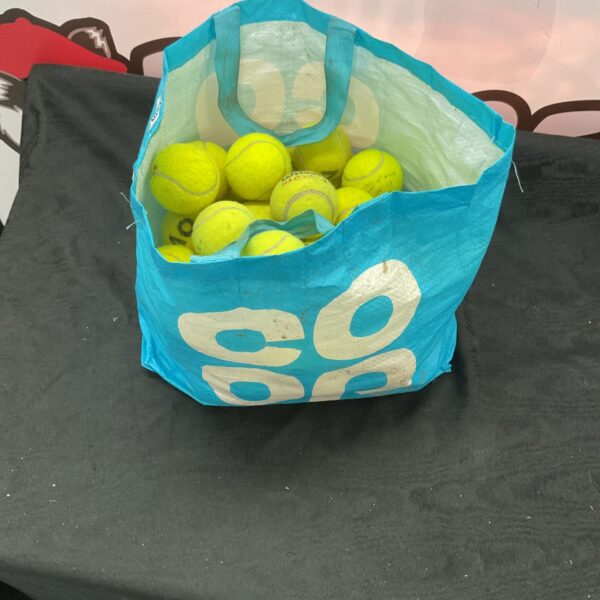 Yellow tennis balls in a plastic bag, used sports equipment.