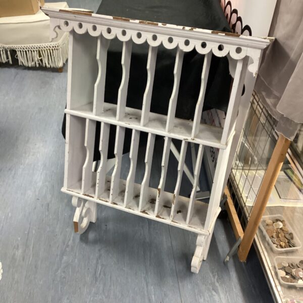 Vintage wooden wall plate rack for displaying collectible plates.