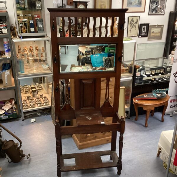 Antique mahogany hall coat stand with mirror and coat hooks.