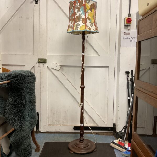 Vintage floor standing lamp with floral shade in a room.