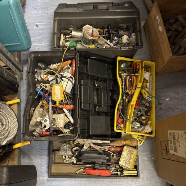Assorted hand tools inside two plastic toolboxes, showing wear.