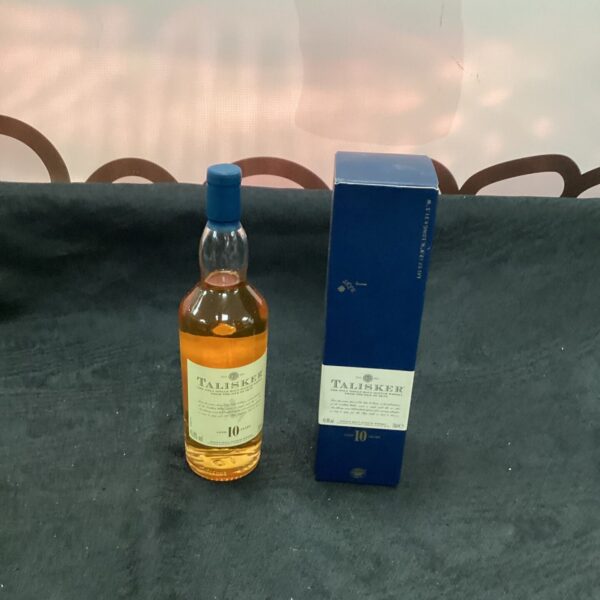 Talisker 10 Year Old whisky miniature bottle on a dark background.
