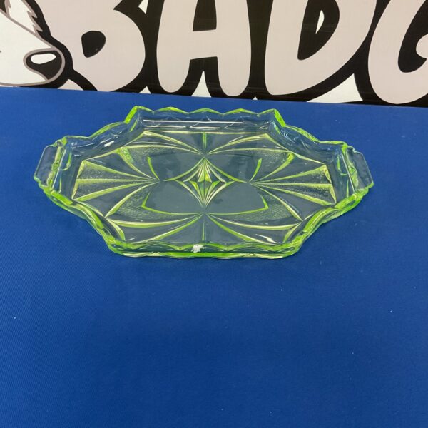 Vintage uranium glass tray with scalloped edge and green hue.
