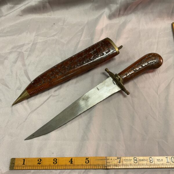 Vintage Indian leaf pattern knife with carved handle and curved blade.