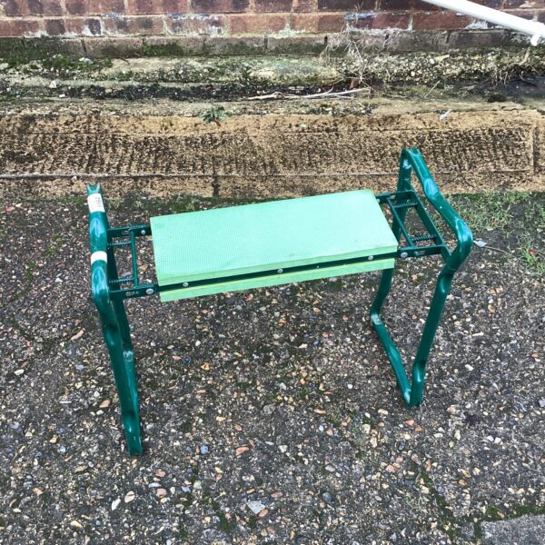 Green folding garden kneeler for comfortable gardening tasks.