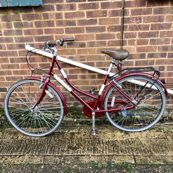 Red vintage ladies push bike with rear rack.