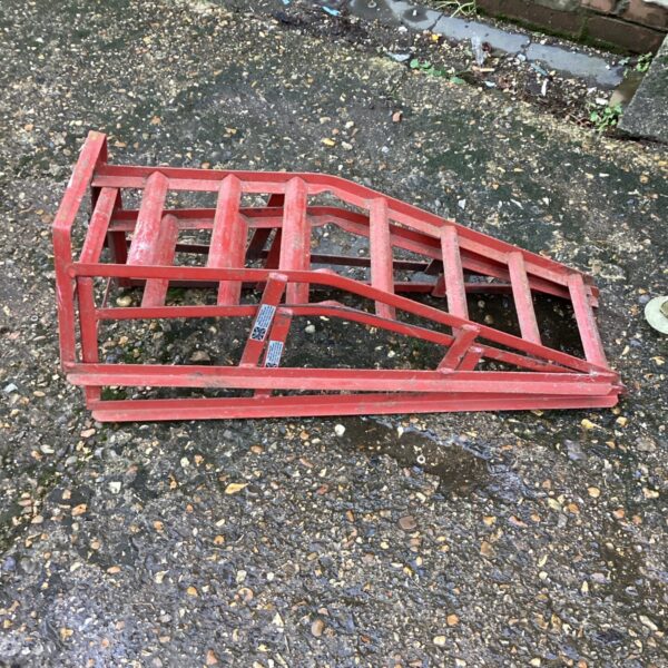 Pair of used steel car ramps for vehicle maintenance.
