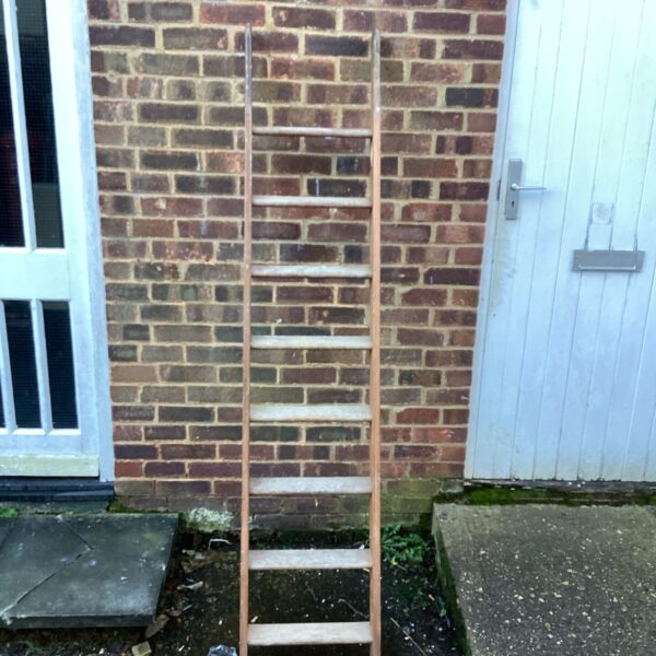 Vintage wooden ladder leaning against a wall.