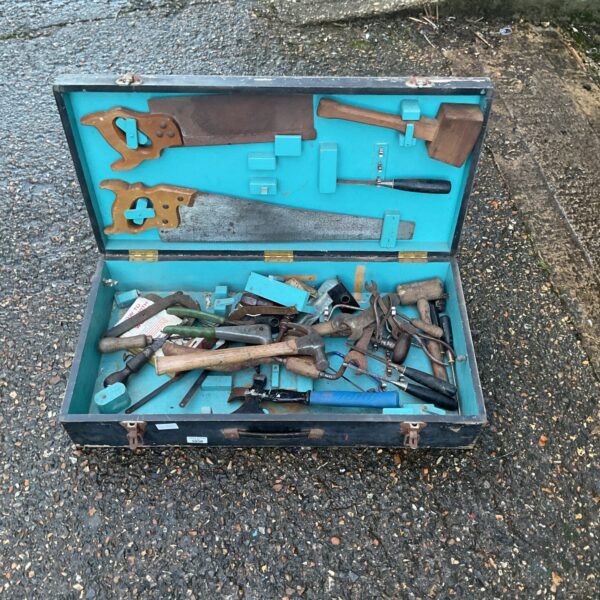 Vintage metal tool box filled with assorted hand tools.