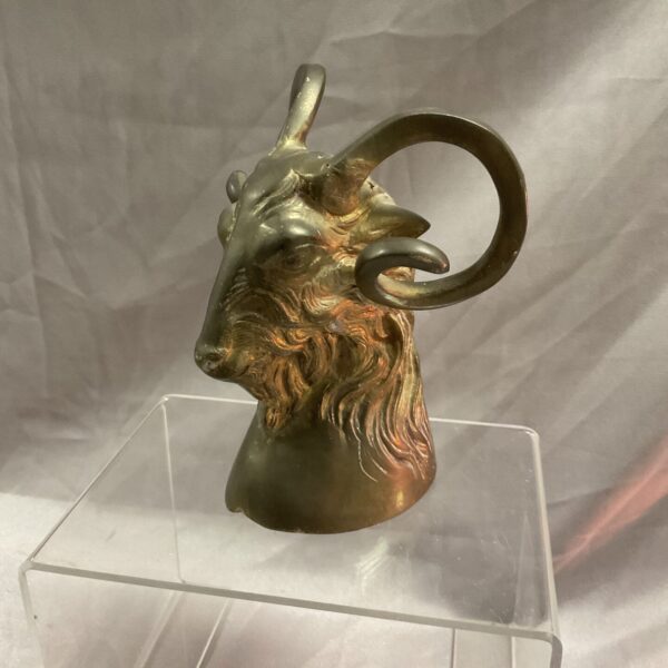 Detailed antique brass rams head sculpture, vintage collectible.