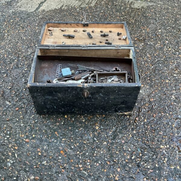 Vintage metal tool box filled with assorted tools.