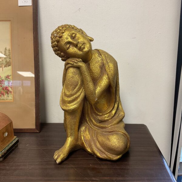 Golden resin Buddha ornament for home decor and meditation.