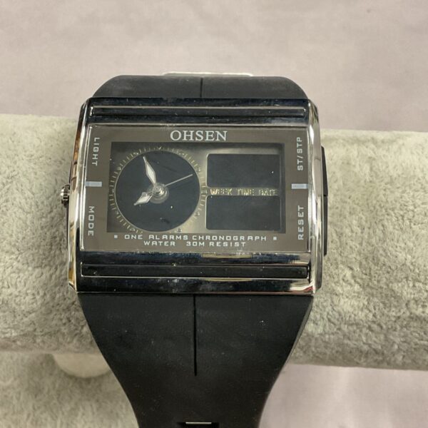 Front view of a black strap Olsen quartz digital wristwatch.