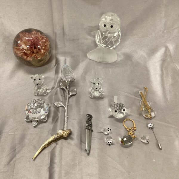 Overview of a diverse Swarovski crystal collection with figurines and a paperweight.