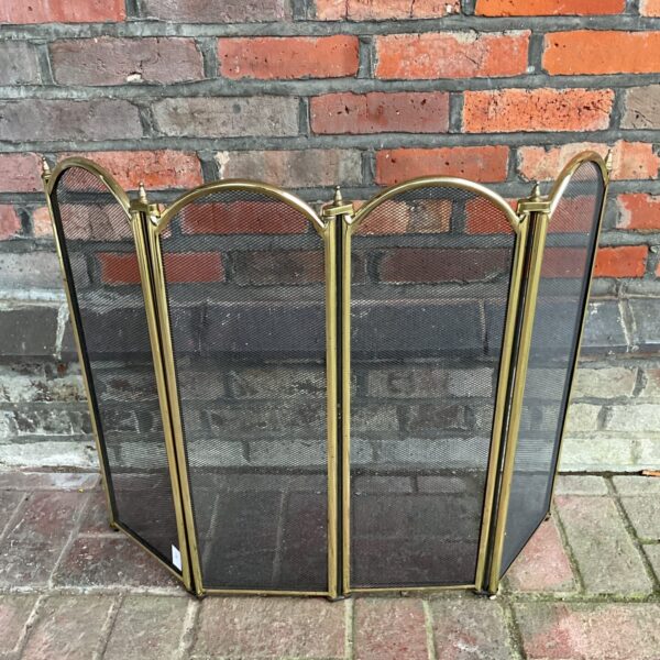 Vintage brass quad-panel folding firescreen for fireplace safety.