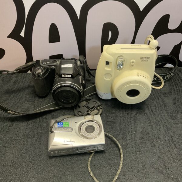 Vintage camera lot featuring Nikon, Olympus, and Instax cameras.