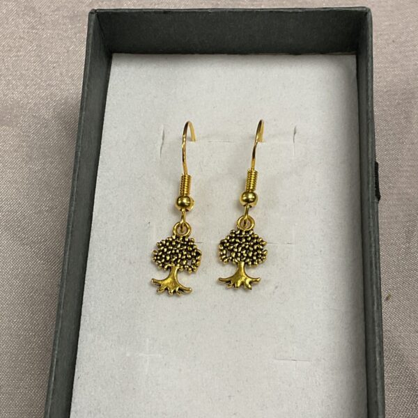 Close-up of silver gilt tree branch earrings with intricate detailing.