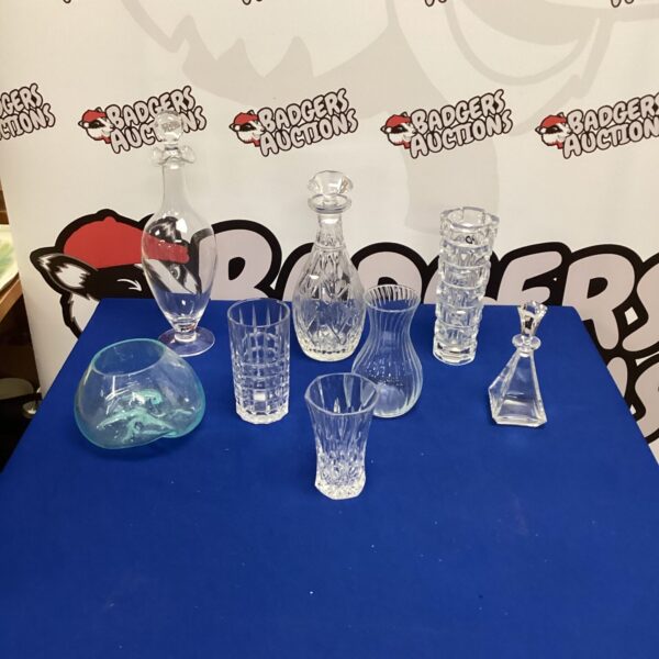 Assorted crystal vases and decanters on display, vintage glassware.