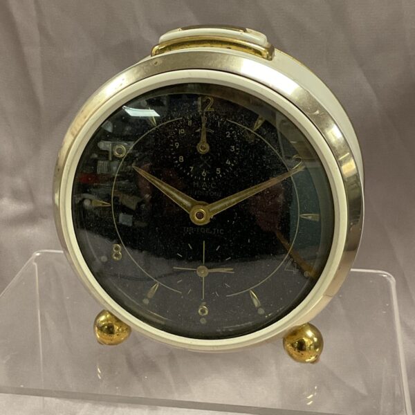 Front view of vintage H A C Trio Tone alarm clock.