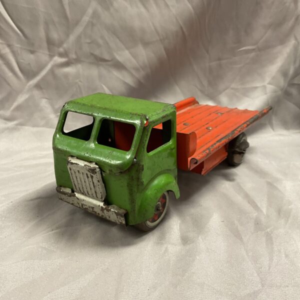 Vintage Mettoy flatbed lorry, side view, colourful tinplate toy truck.