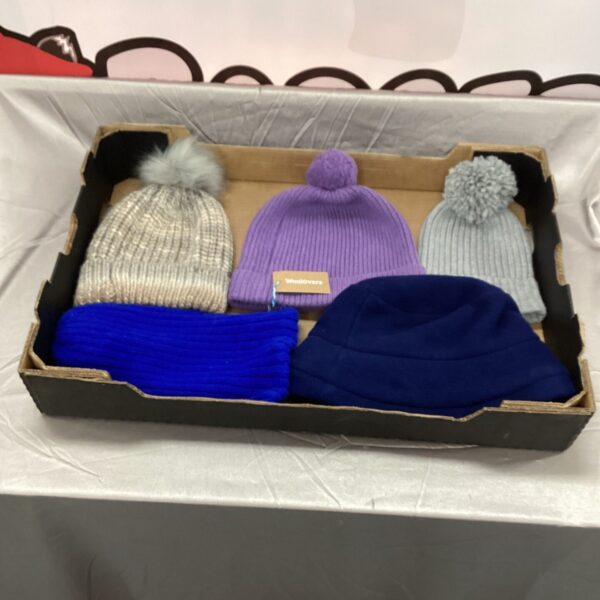 Tray of colourful ladies' wool bobble hats for winter.