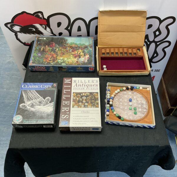 Vintage games lot featuring marble solitaire and jigsaw puzzles.