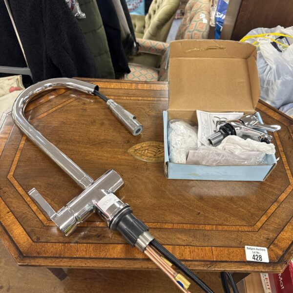Chrome basin mixer tap and extendable kitchen tap in packaging.