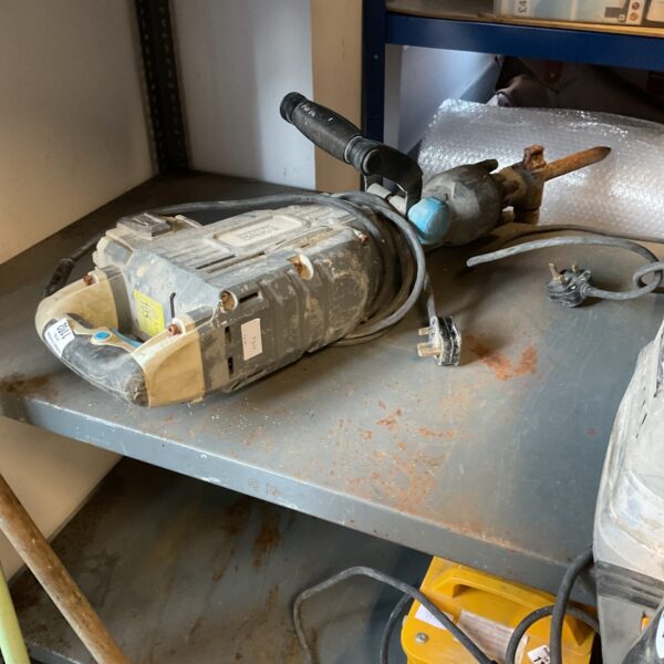 Side view of a used Mac Allister concrete breaker demolition tool.
