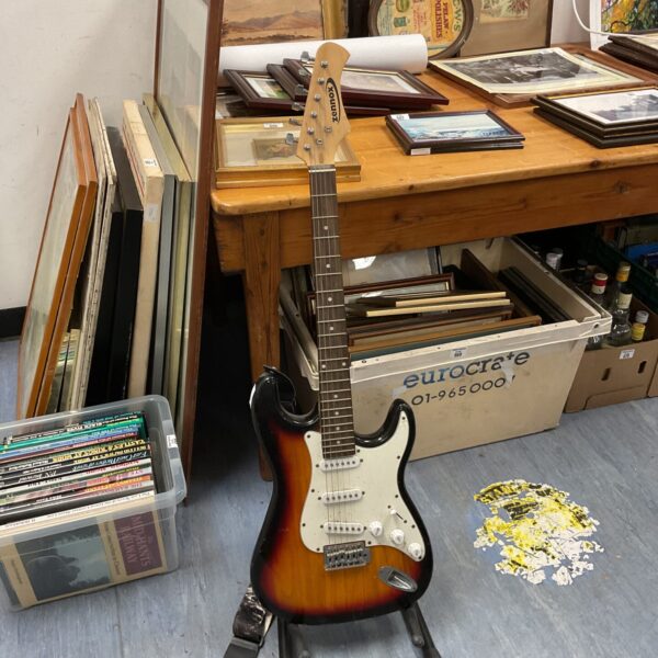 Sunburst Zennox electric guitar displayed on a stand.